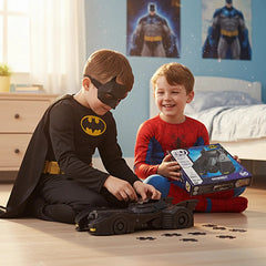 4D Build DC Batman Retro Batmobile 3D Puzzle Model Kit is held by two boys in superhero costumes, smiling on a wooden floor.