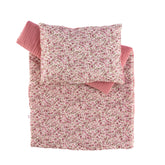 Floral pink and white comforter and pillow set for dolls, showcasing cozy quilted design and pattern.