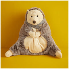 Plush hedgehog sitting upright against a bright yellow background, featuring soft brown fur and a cozy beige belly, with a cute facial expression and small paws.