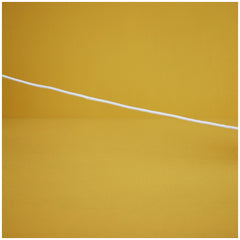 A white cotton cord stretches across a vibrant yellow background, suggesting playfulness and connection for children's toys.
