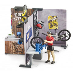 Toy bike shop playset with action figure, bike repair station, helmets, and vibrant shop accessories.