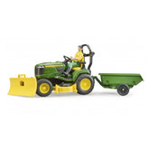John Deere lawn tractor toy with snow plough, driven by a figure, attached green trailer.