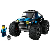 Blue LEGO® City monster truck with oversized rubber tires, accompanied by a smiling driver minifigure and a black helmet.