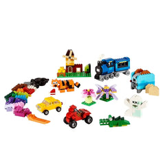 Assorted LEGO bricks from the Classic Medium Creative Brick Box, including colorful cars, a train, flowers, a house, and animals, arranged on a white background.