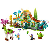 Colorful LEGO® DREAMZzz™ Stable of Dream Creatures set, featuring a whimsical house with a spinning windmill, playful dreamlings, and a green deer.