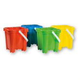 Four square-shaped beach buckets in red, blue, green, and yellow, with white handles, arranged in a row.