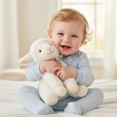 Artesavi White Lamb Plush 18 cm being held by a smiling child in a cozy, softly lit indoor setting.