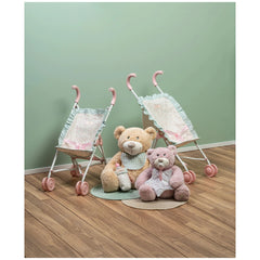 Two teddy bears seated between pink-handled strollers on wooden floor, green wall backdrop.