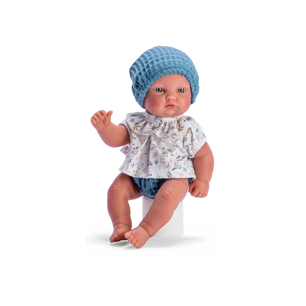 Gordi doll in a floral shirt, blue hat, and panties, sitting with articulated limbs and light-colored eyes.