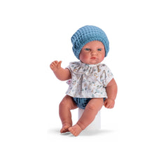 Gordi doll in a floral shirt, blue hat, and panties, sitting with articulated limbs and light-colored eyes.