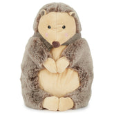 Piksi the Hedgehog, a soft stuffed animal with a cream belly and gray, fuzzy exterior, holds its paws together. It features a cute face with black eyes and a small brown nose, topped with a simple striped collar, inviting cuddles and imaginative play.