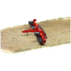 Red Bruder Cambridge Roller toy on dirt path with green patches, featuring black rollers and realistic detailing.
