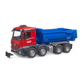 Red and blue Bruder MB Arocs halfpipe tipper truck with detailed cabin and multiple wheels on a white background.