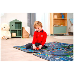 Dickie Playmat featuring a child playing with colorful plastic toy cars on a vibrant multi-colored track on a wooden floor.