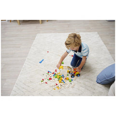 Eichhorn Constructor 3in1 construction set being played with by a young child on a white carpet, featuring a car and train.