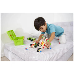 Eichhorn Constructor 3in1 Race Car set in use by a young boy on a bed, featuring colorful components and a train track.
