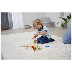Eichhorn Constructor Expansion Set is being explored by a child on a carpeted floor in a modern, minimalist room.