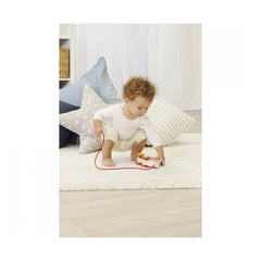 Eichhorn Pull Back Hedgehog with a child playing on a white rug, engaging with toys in a cozy indoor setting.