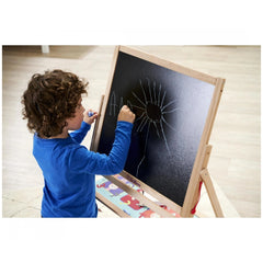 Eichhorn Standing Blackboard with a child drawing on it using blue chalk, set in a cozy room with a colorful rug.