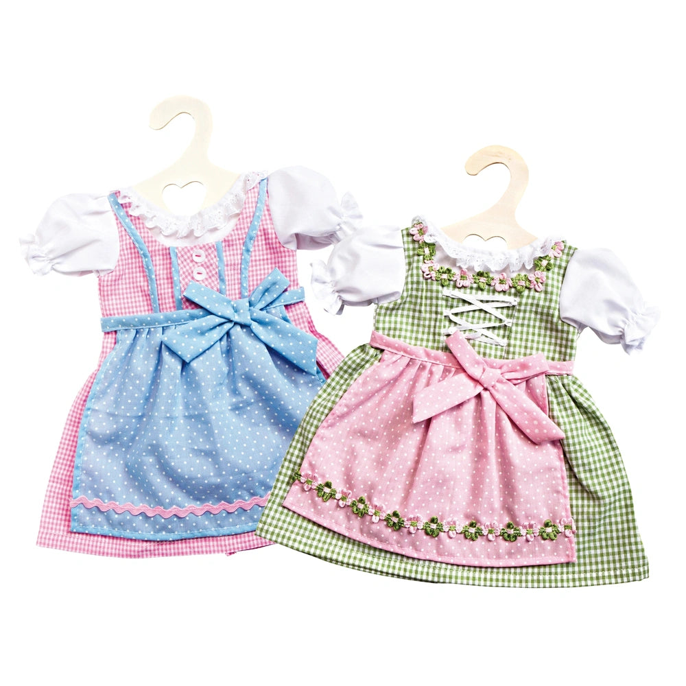 Heless Dirndl playset features two dresses: one blue with pink polka dots, and one pink with green checkers, both with lace t
