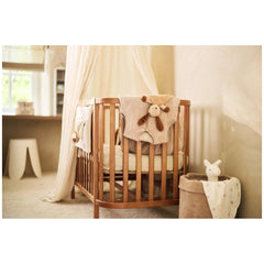 Jollein pacifier cloth featuring animal friends on a white fabric-draped wooden crib in a cozy nursery setting.