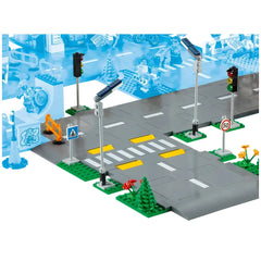 LEGO® City Road Plates construction set featuring gray road plates with yellow lane markings, traffic lights, road signs, and greenery.