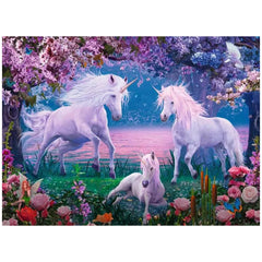 Three whimsical unicorns stand in a vibrant flower-filled field under a pastel gradient sky at sunrise or sunset.