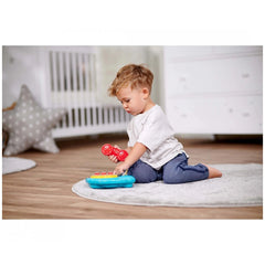 Simba ABC Colorful Telephone - Child playing with a toy phone on a rug in a light-toned bedroom with a crib in the background