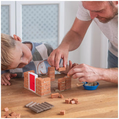 Teifoc fire station set with a child and man interacting over Lego bricks on a wooden table in a cozy indoor setting.