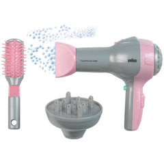 Theo Klein Braun hairdryer in pink and gray with diffuser, alongside a pink-bristled hairbrush with silver handle.