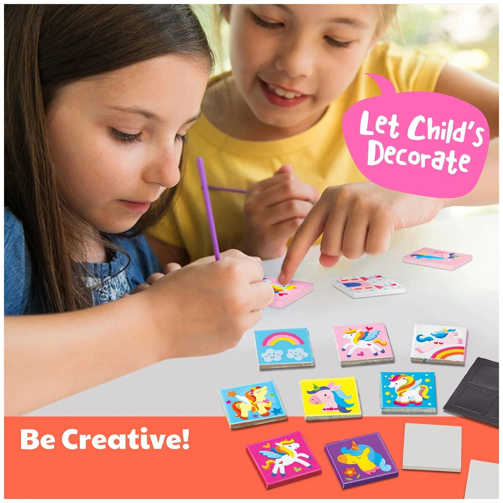 4M Unicorns Mini Tile Arts with children using purple crayon, surrounded by rainbow and unicorn cards on a wooden table.