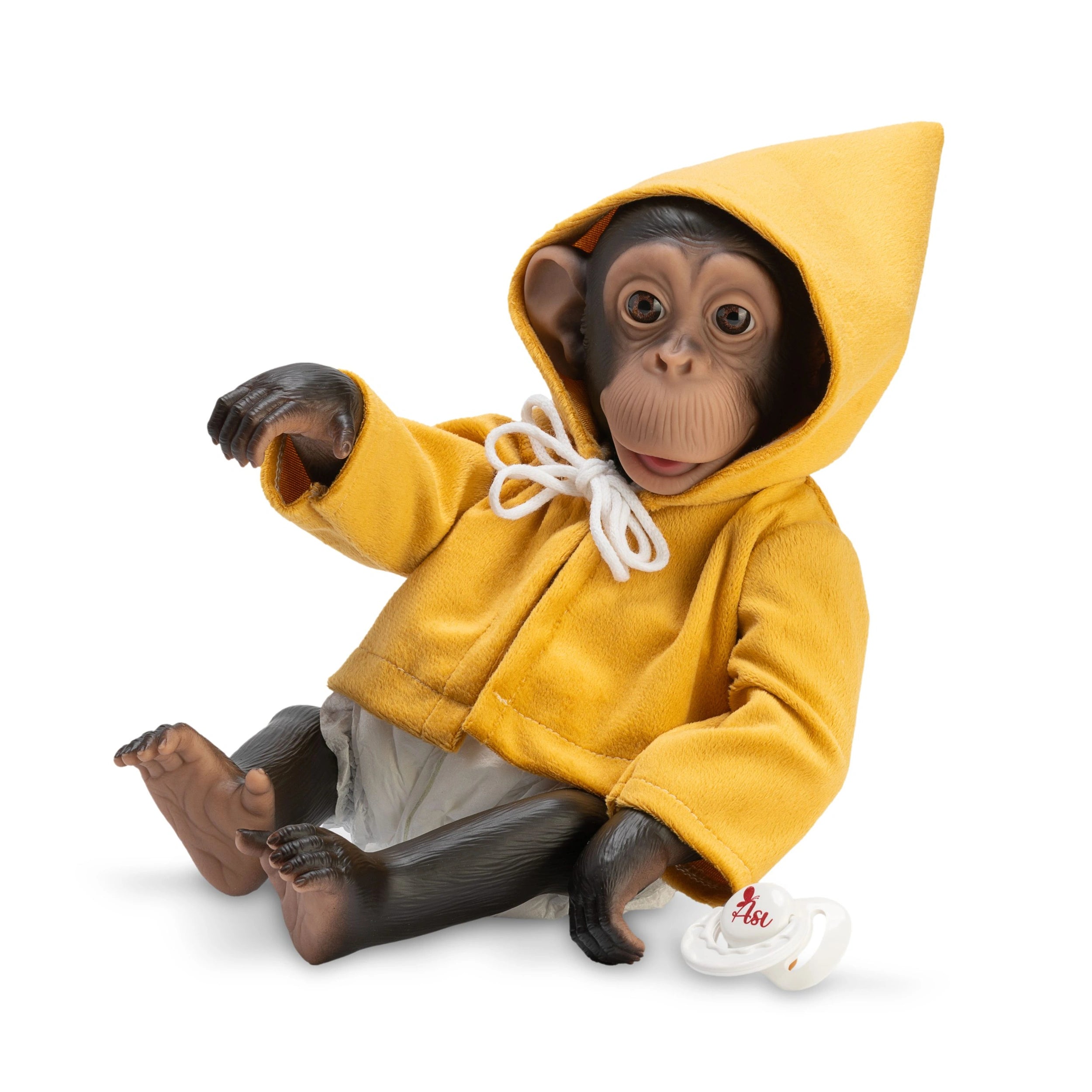 Chimpanzee doll wearing a mustard coat, sitting with a pacifier nearby.