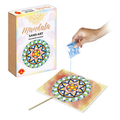Hand pouring craft material from a blue bag onto a vibrant, circular mandala design on a stick.