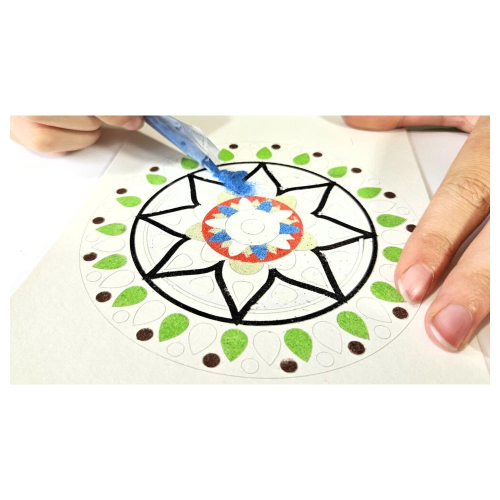 Blue paintbrush applying paint to a colorful circular mandala design on a white surface, featuring red, green, and blue eleme