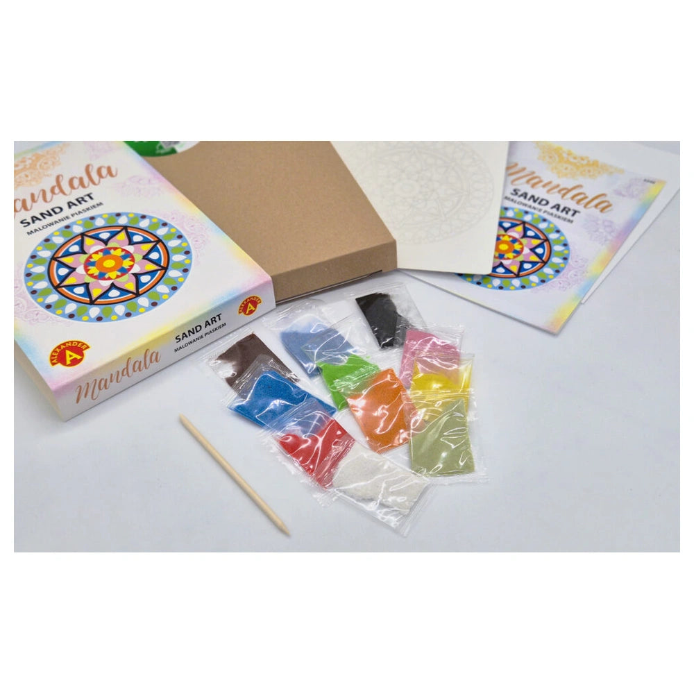 Sand art kit featuring colorful sand bags, a wooden stick, and two boxes labeled "SAND ART" on a light surface.
