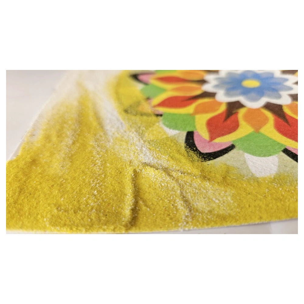 Sand art mandala featuring a colorful flower motif surrounded by a white halo on a smooth surface.