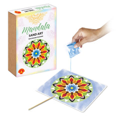 Mandala Sand Art packet held in hand, pouring vibrant sand onto a colorful flower design on a flat surface.