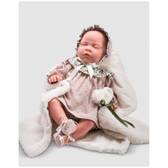 Reborn doll Gisela in a pink dress, bonnet, and booties, resting on a white blanket with realistic closed eyes.
