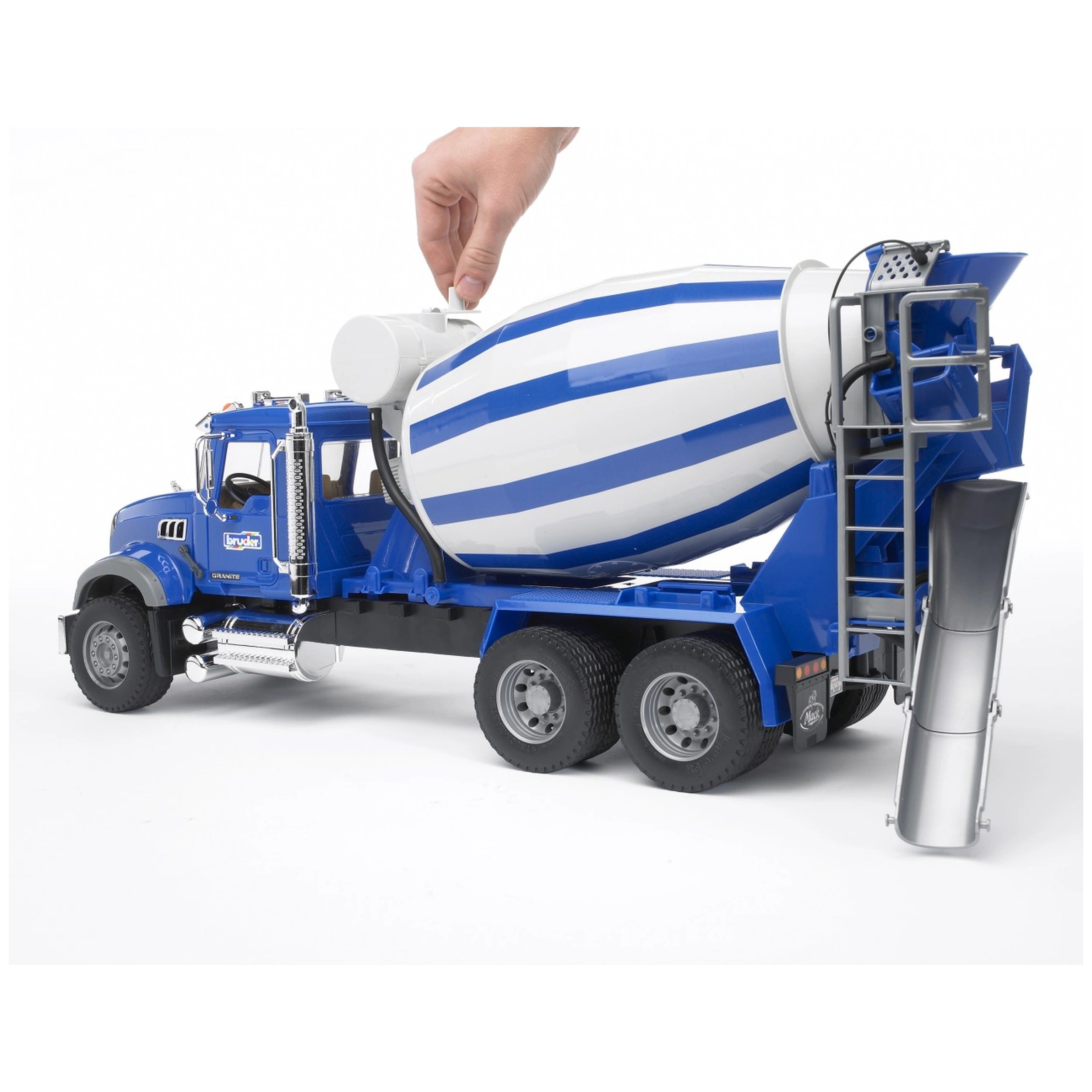 Hand turning the blue and white drum of a Bruder MACK Granite cement mixer toy truck with open door and chrome details.