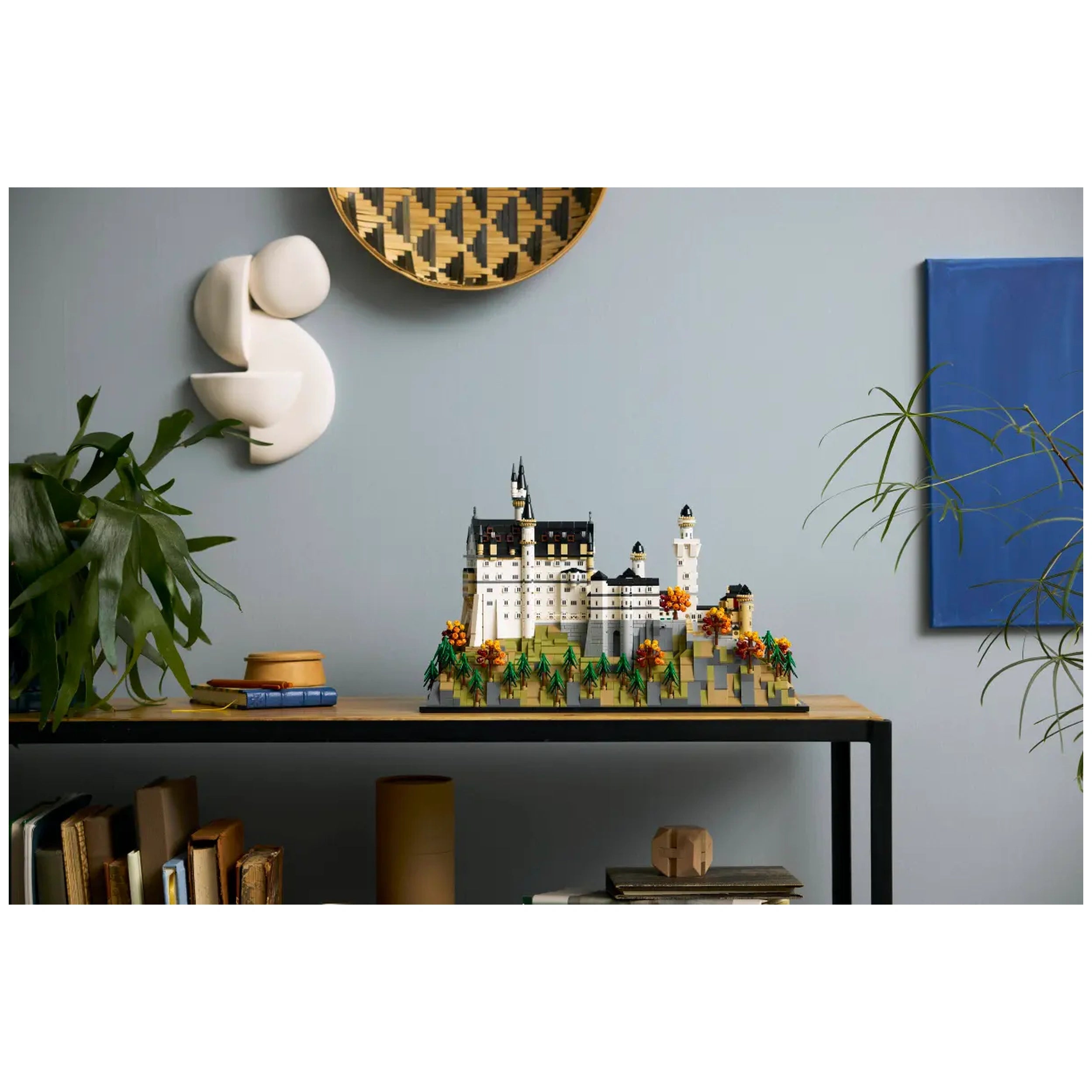 LEGO Architecture Neuschwanstein Castle model set displayed on a wooden table, featuring intricate details, colorful foliage, and creative architectural elements.