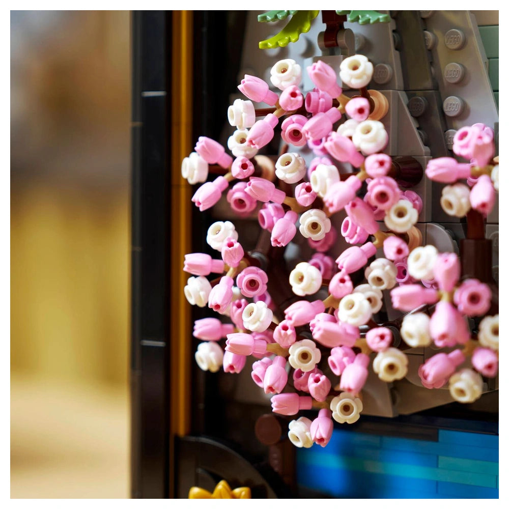 LEGO construction set features a decorative arrangement of pink and white flowers on a gray and white Lego tree structure.