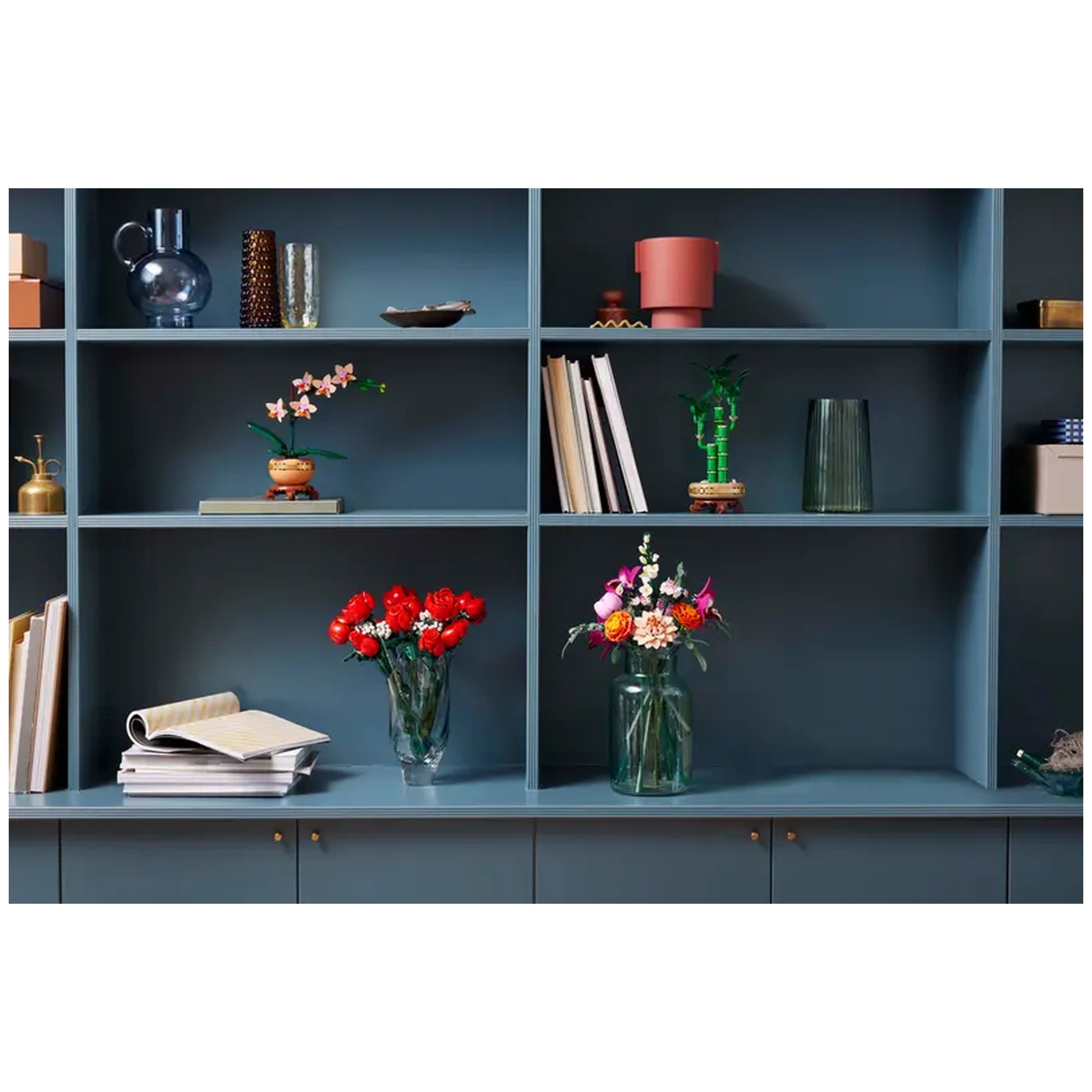 Colorful floral arrangements on blue shelves include red roses, pink and white flowers, and green bamboo. Decorative items and books are also present.