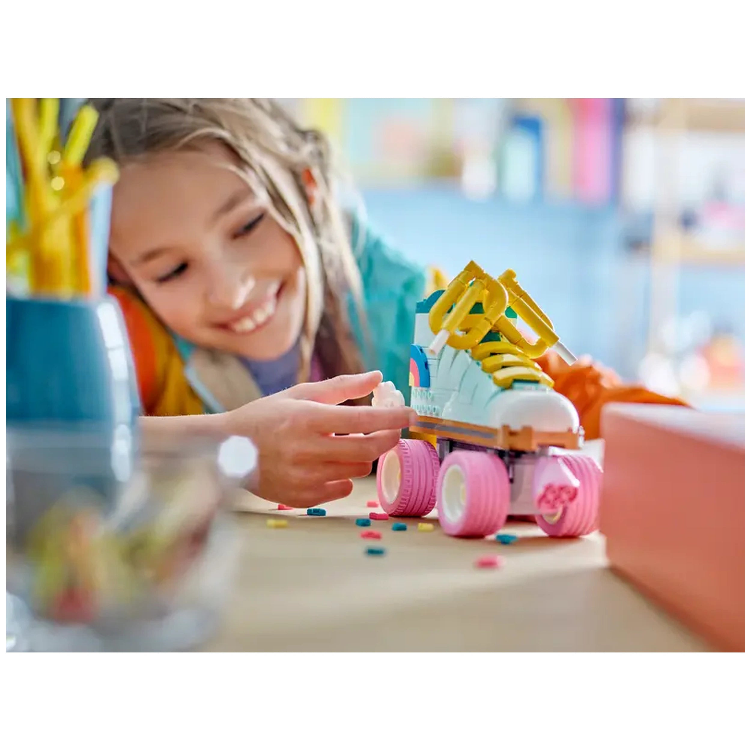 A child joyfully assembles a colorful LEGO Creator Retro Roller Skate on a table, surrounded by vibrant building pieces and decor.