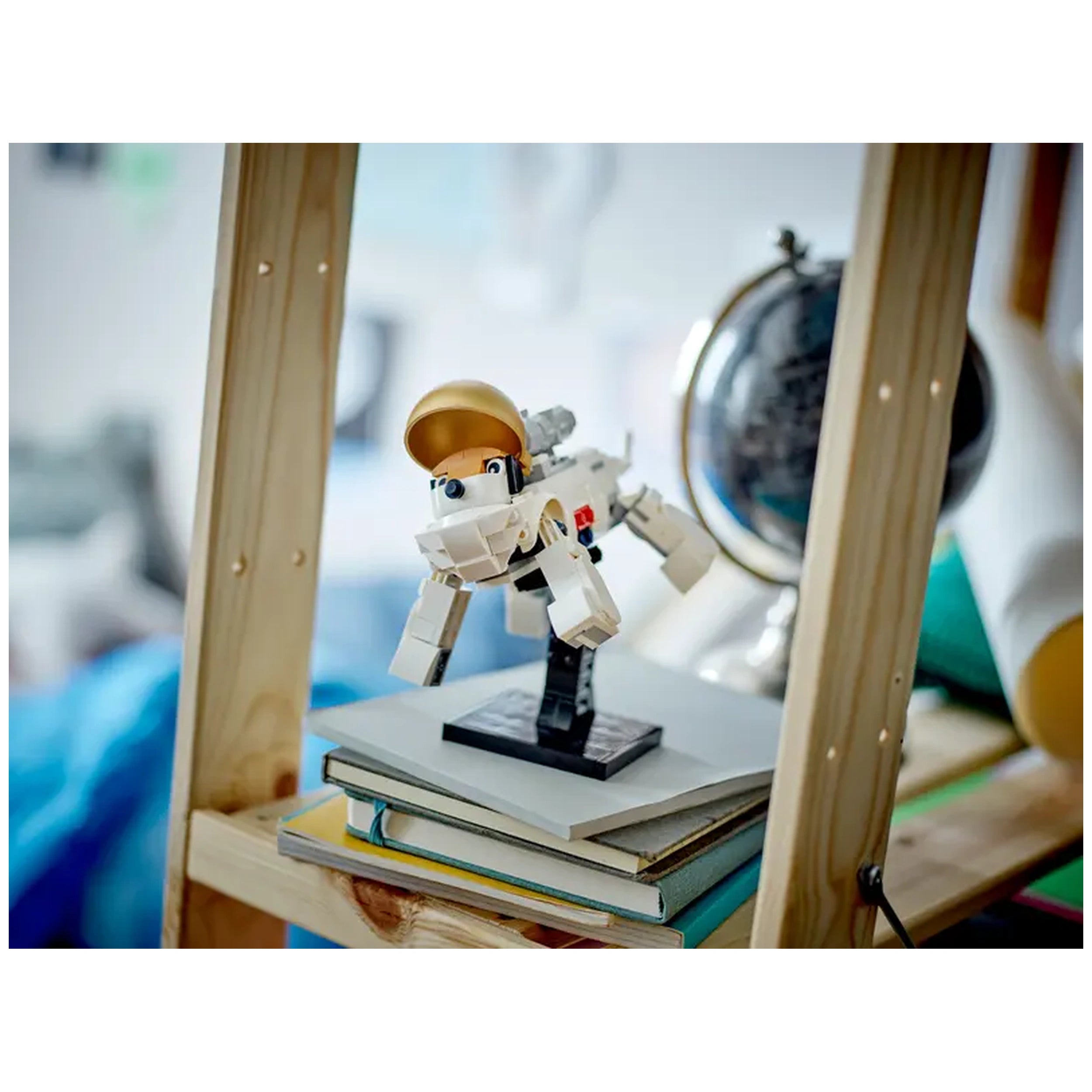 LEGO Creator Space Astronaut figure in action pose, with a golden visor and jet backpack, displayed on bookshelves in a cozy room.