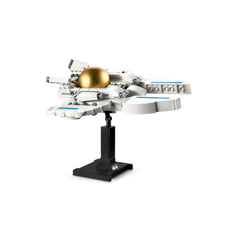 A white LEGO spaceship model with a golden dome, displayed on a black stand, featuring blue accents and intricate details.