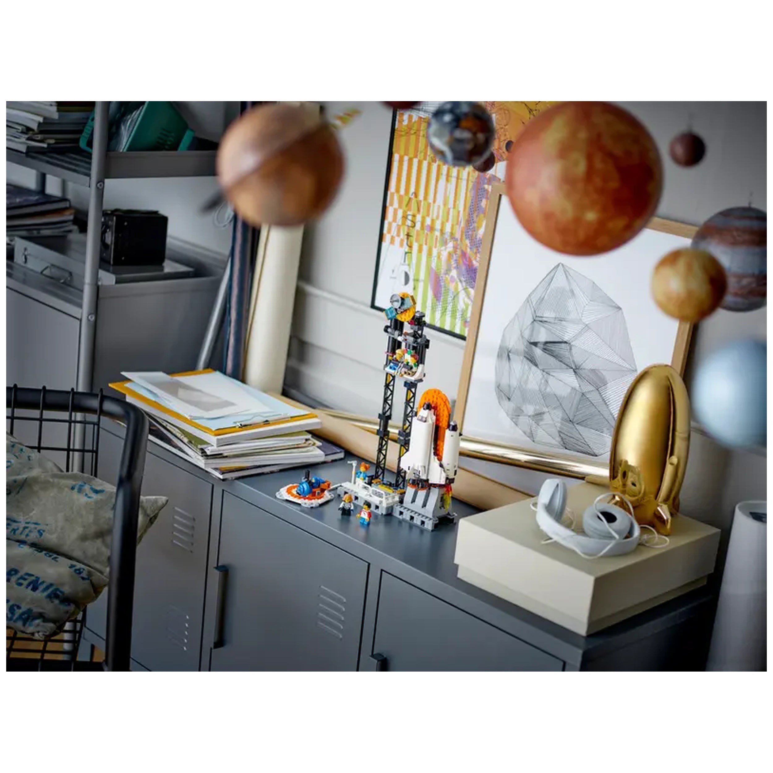LEGO® Creator 3in1 Space Roller Coaster set on a gray cabinet, surrounded by colorful planets and art.