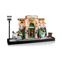 LEGO Icons French Café construction set showcasing a charming bistro facade with flower pots, outdoor seating, and a classic streetlight.
