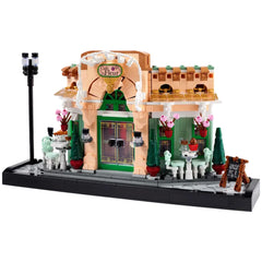 LEGO® Icons French Café set featuring a charming bistro facade with green accents, flowerpots, elegant seating, and a sidewalk.