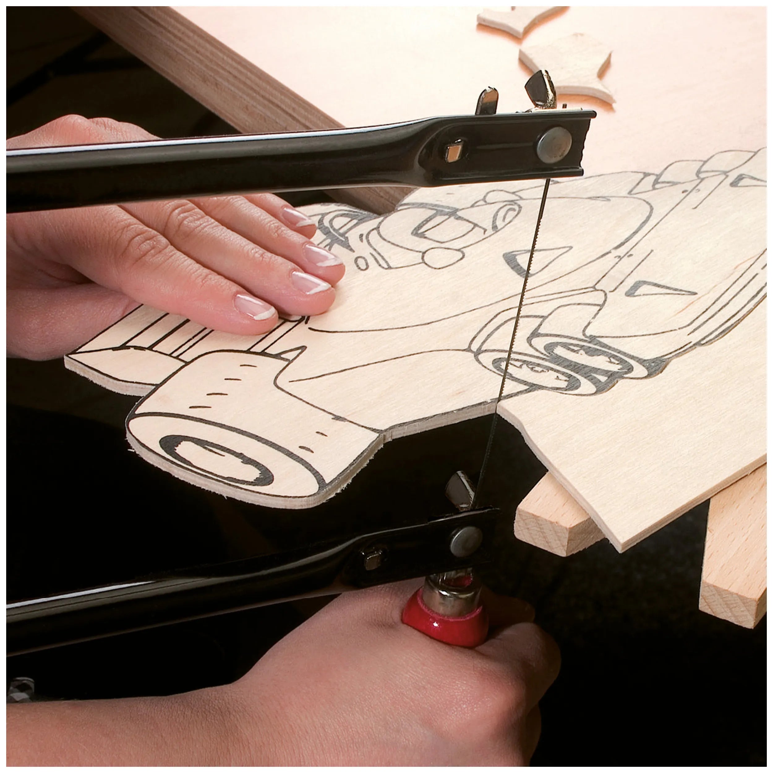 Hands using a fretsaw to cut intricate designs into wood, showcasing the Prebaro Fretsaw Kit's precision.