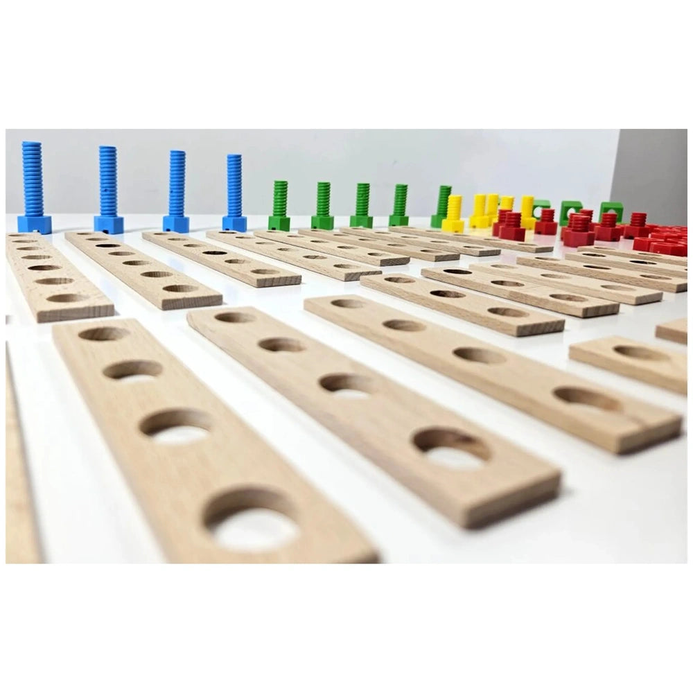 Wooden planks with holes, blue, green, yellow, and red plastic screws on a white surface, part of a construction set.